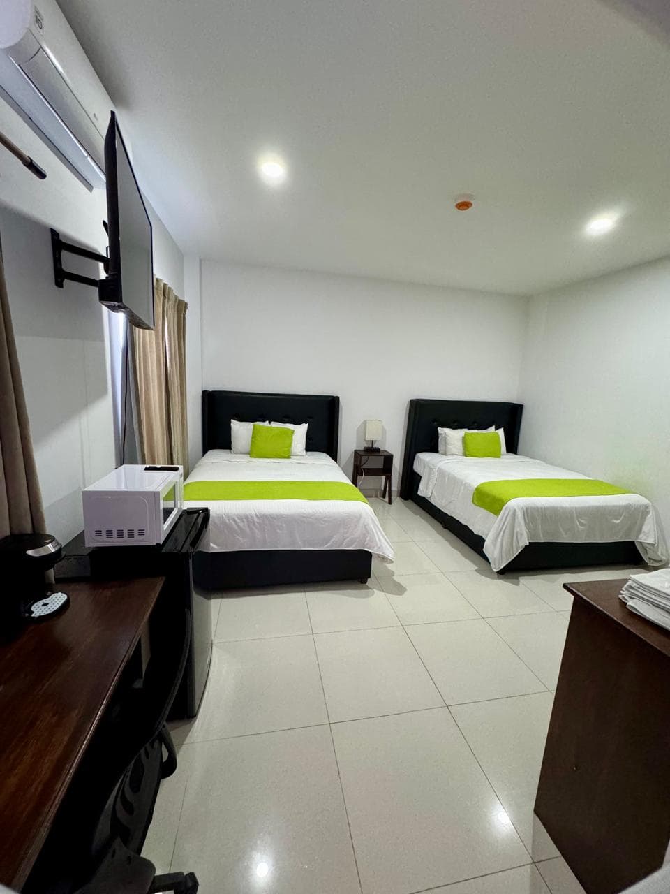 two queen bed with television and computer table